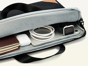 Gray laptop bag with electronic devices inside on a light gray background