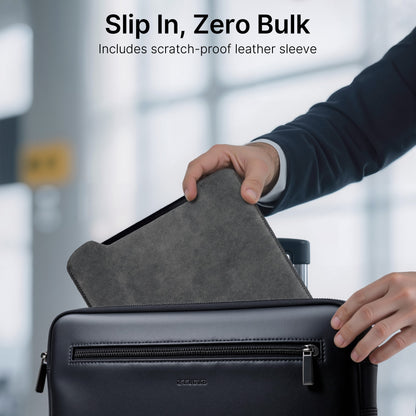 Person placing a gray scratch-proof leather sleeve into a black suitcase with a blurred background.